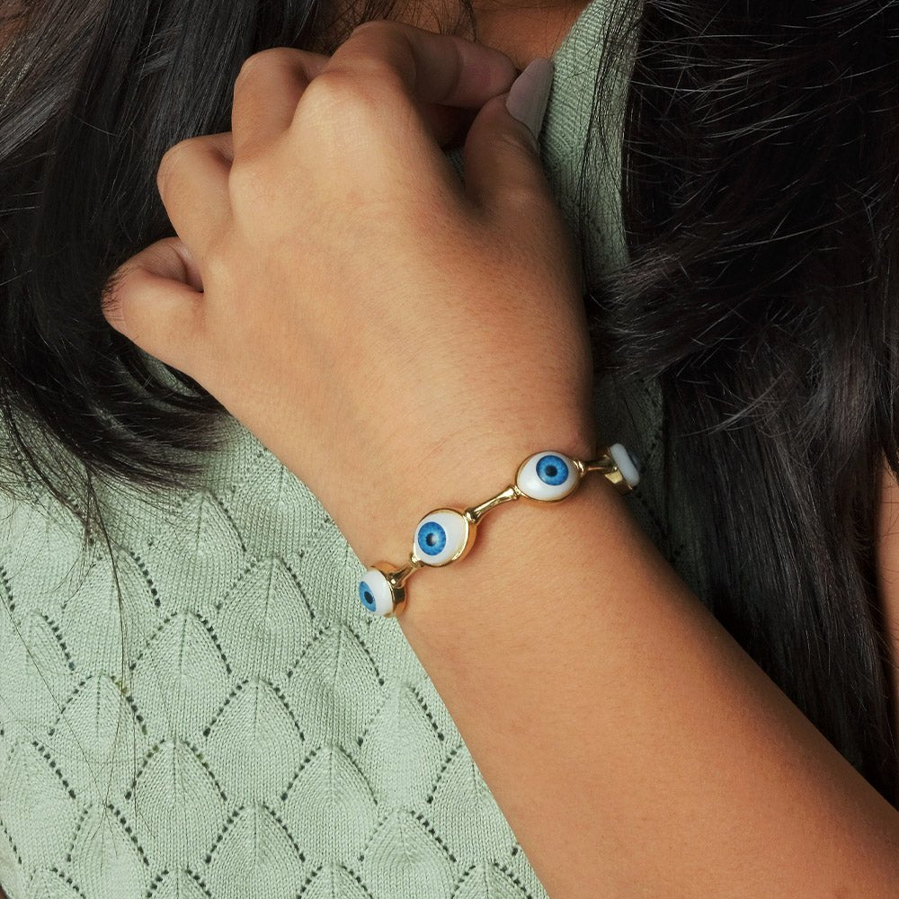 Elegant golden evil eye bangle with multiple charm detailing and an adjustable anti-tarnish finish, perfect for everyday styling, protective charm looks, and chic stacked wear.