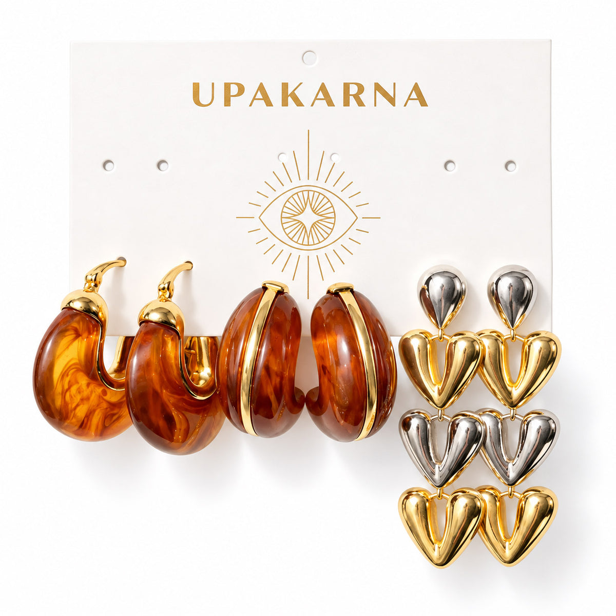 Upakarna earring display card featuring three pairs of statement earrings: amber resin hoops, chunky amber hoops with gold accents, and mixed gold and silver layered heart drop earrings on a clean white background.