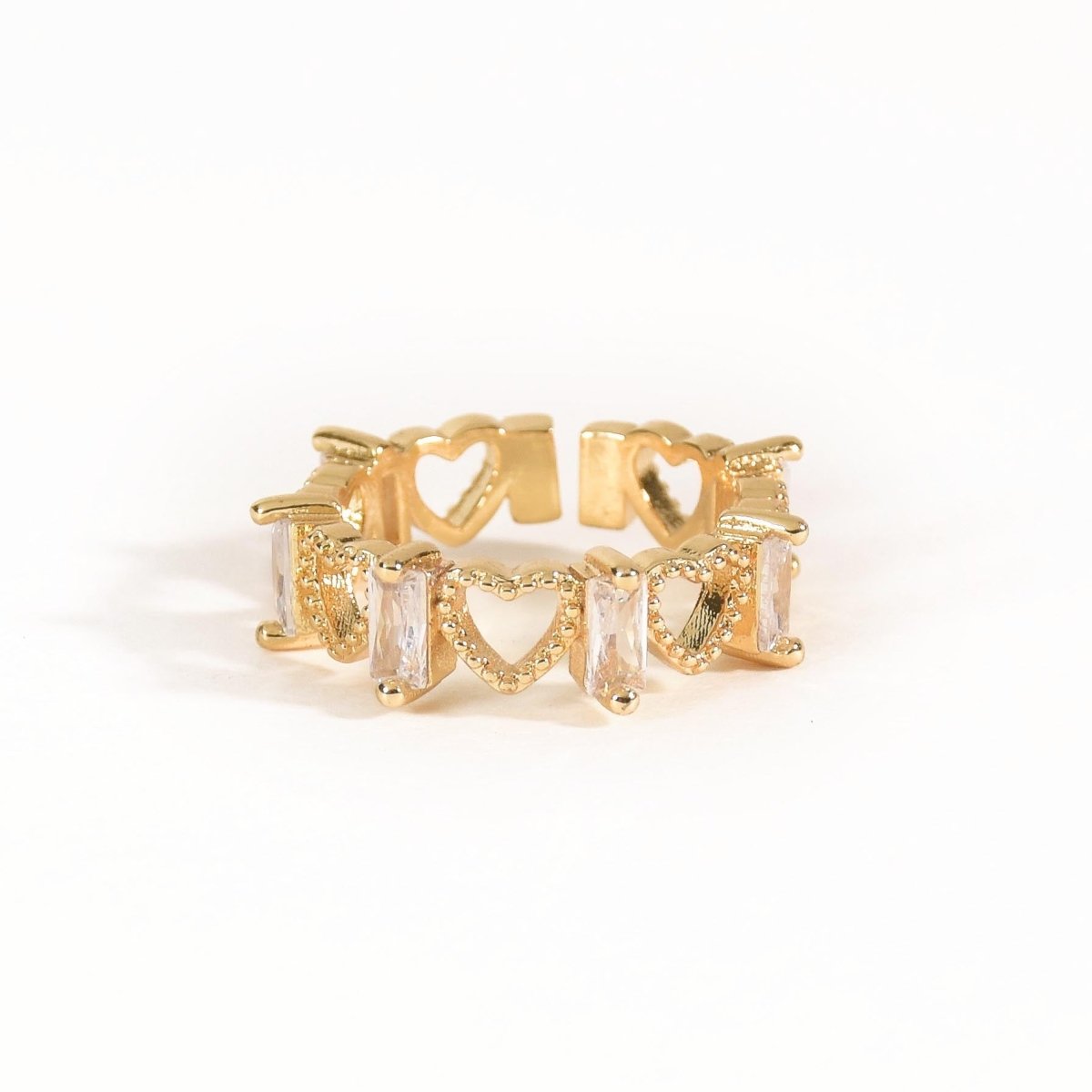 Elegant golden ring with heart motifs, sparkling baguette-cut stones, and an adjustable anti-tarnish finish, perfect for timeless styling, stacking, and everyday sophistication.

