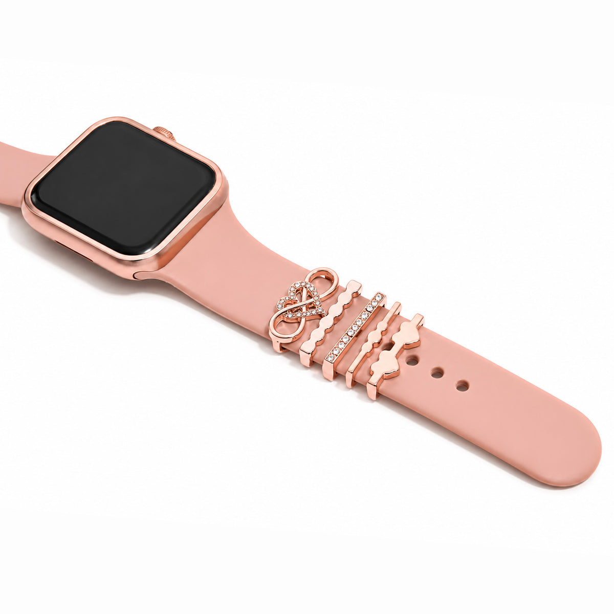 Zoomed-out view of a rose gold smartwatch with a pink strap decorated with a sparkling peace symbol charm, wavy rose gold bands, and a pavé crystal bar on a white background.