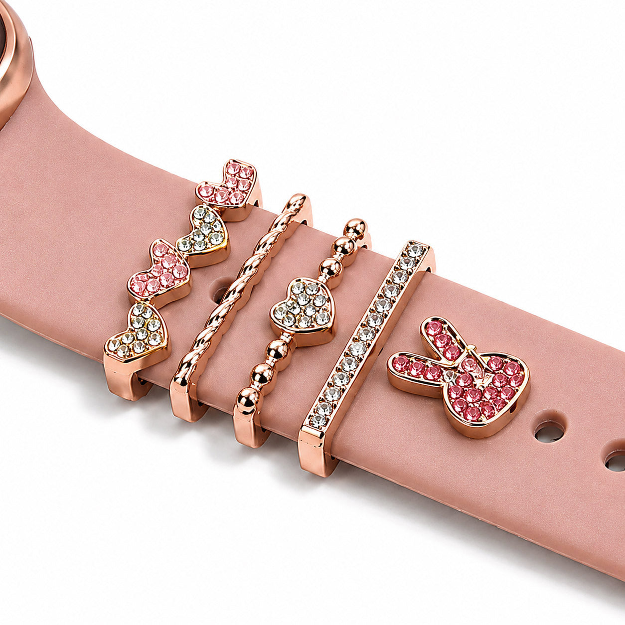 Rose gold smartwatch strap decorated with sparkling pink butterfly charms, crystal heart charms, a twisted chain charm, and a pavé crystal bar.