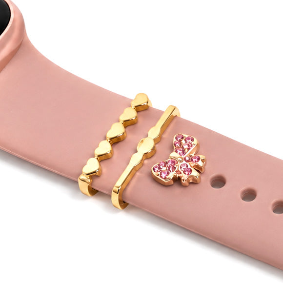 Pink smartwatch strap decorated with gold heart-shaped bands, a wavy gold band, and a sparkling pink butterfly charm on a white background.