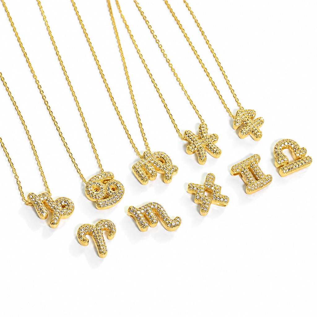 Gold tone crystal studded zodiac sign necklaces with individual zodiac symbol pendants, displayed on a white background.