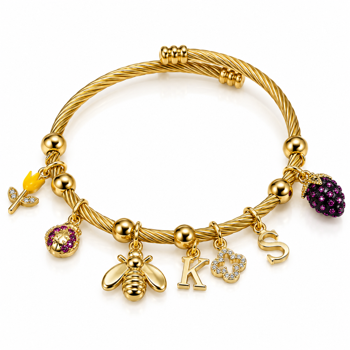 Gold-toned twisted wire charm bracelet featuring a bee charm, purple jeweled fruit charm, letter K, sparkling flower, and letter S charms on a white background.