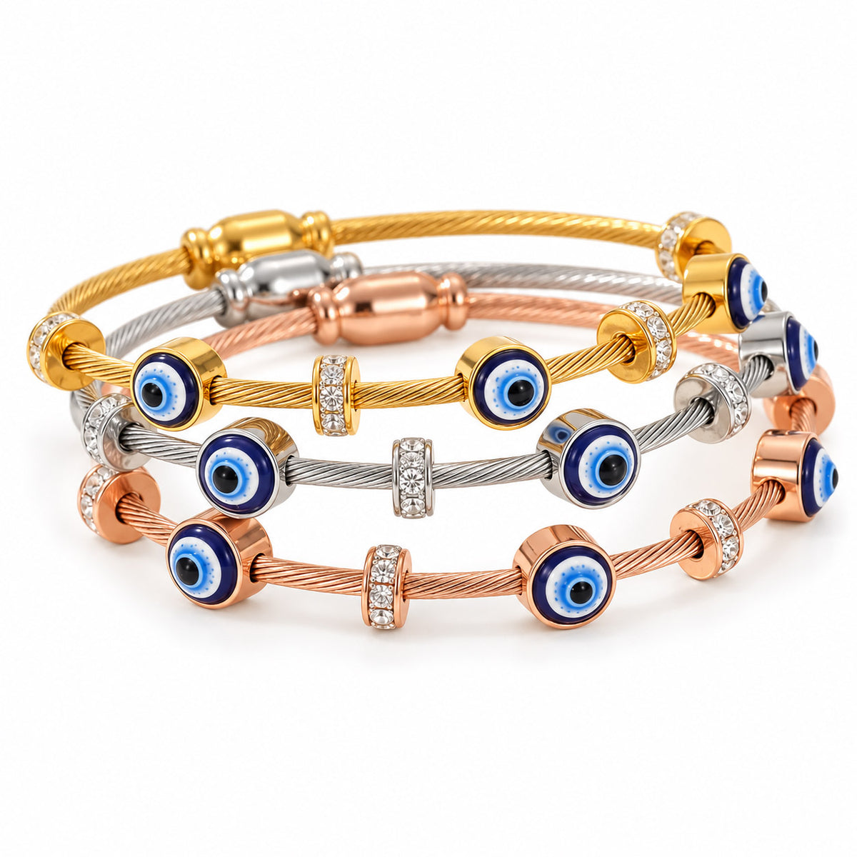 A product photo of a stacked set of tri-color twisted cable wire bracelets featuring yellow gold, silver, and rose gold finishes, adorned with alternating blue-and-white enamel evil eye charms and rhinestone spacers.