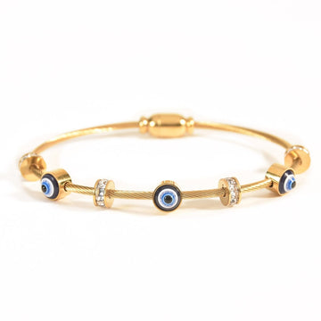 Gold evil eye cable bangle featuring blue enamel evil eye charms, sparkling crystal spacer beads, and a sleek twisted cable design. Finished with an anti-tarnish coating and displayed on a clean white background, this adjustable bracelet.