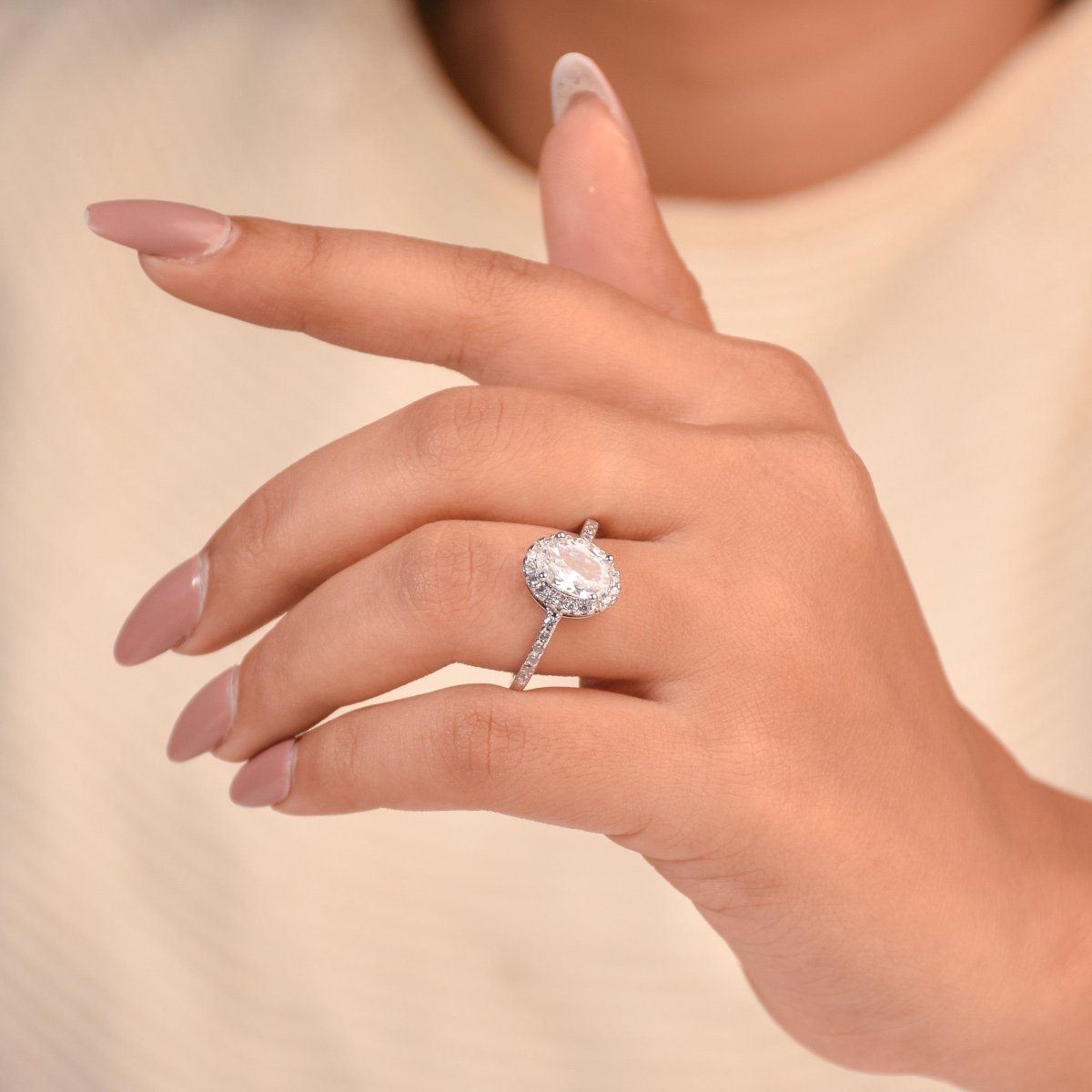 Elegant silver ring featuring a brilliant oval-cut center stone, sparkling halo, and pavé band in an anti-tarnish finish. a timeless adjustable design perfect for gifting and everyday elegance.