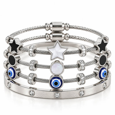 A product photo of a stacked set of silver-tone bracelets featuring twisted cable wire bands, star and circular mother-of-pearl stations, black enamel accents, blue-and-white evil eye beads, and a crystal-set bangle.