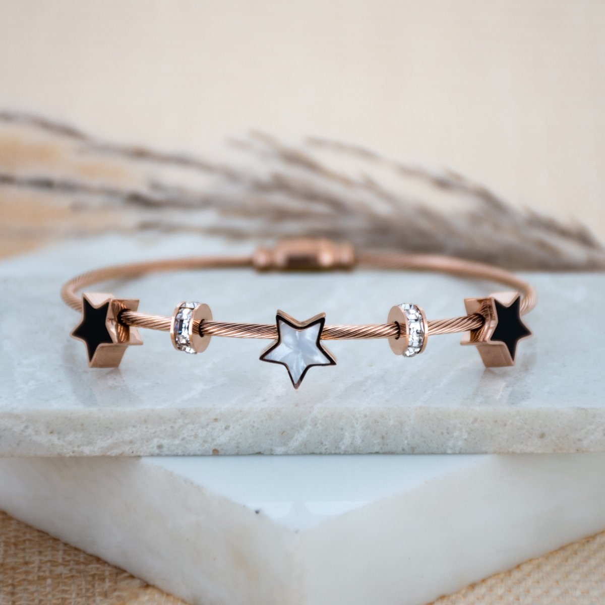 Elegant star bangle with delicate celestial detailing and an anti-tarnish finish, available in rosegold, perfect for everyday wear, youthful styling, and chic minimal looks.
