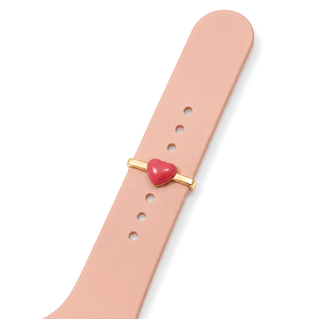 Red heart watch charm styled on a peach watch strap, showing the charm and adjustable strap holes.