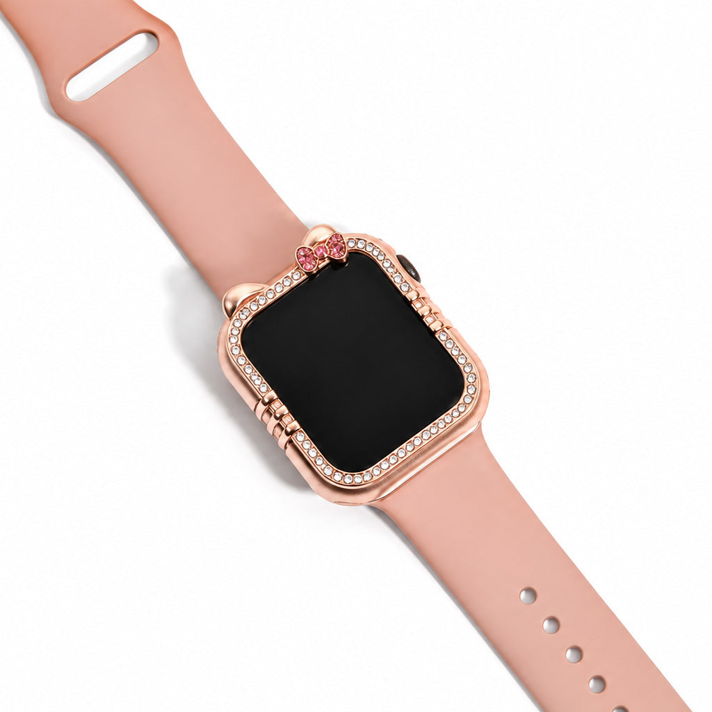 Rose gold-tone smartwatch displayed on a blush pink strap, featuring a crystal-studded cat-ear frame with whisker accents and a pink stone bow detail, on a white background.