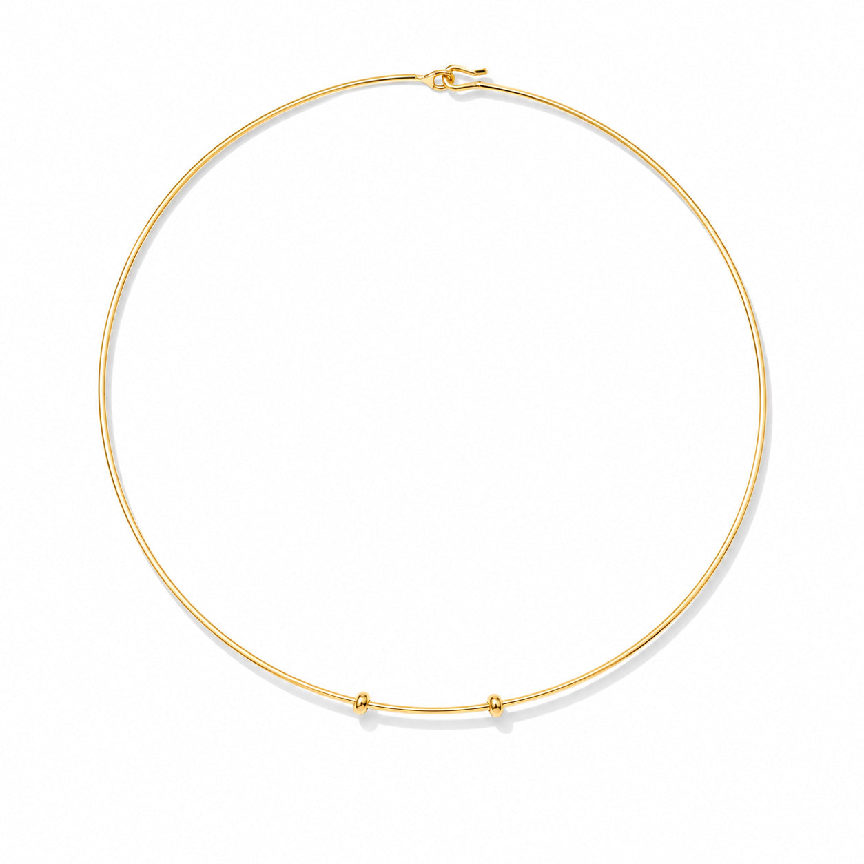 Minimal gold choker necklace with a delicate circular wire design and small bead accents on a white background.