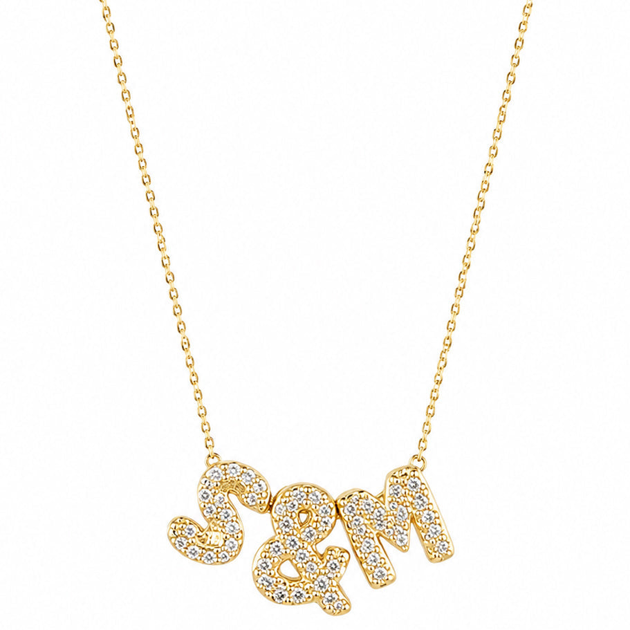 Gold-plated personalized necklace featuring sparkling pavé initials “S & M” on a delicate chain, displayed on a clean white background.