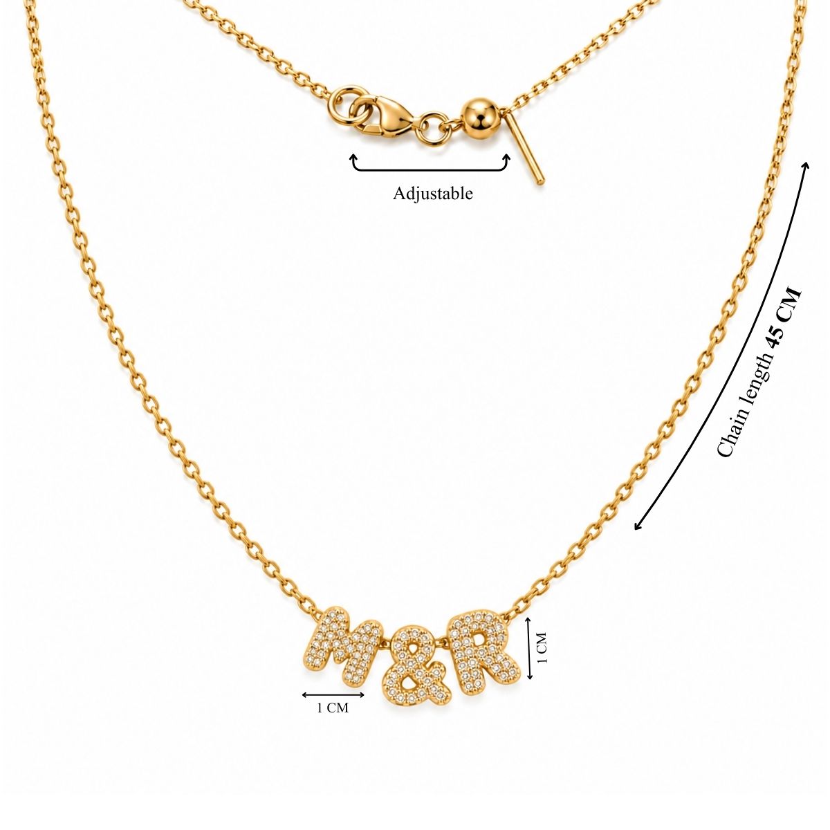 Product measurement image showing a gold chain necklace with a total length of 45 cm, an adjustable clasp mechanism, and 1 cm tall rhinestone-encrusted letter charms that spell "M&R"