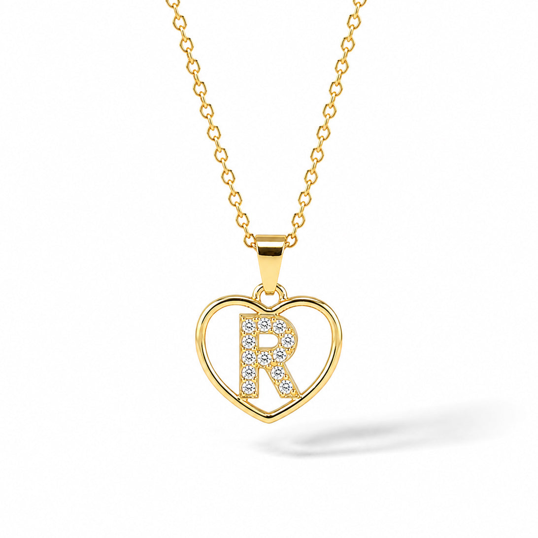 Gold-plated personalized heart necklace featuring a sparkling pavé “R” initial inside an elegant heart outline, displayed on a delicate gold chain against a clean white background.