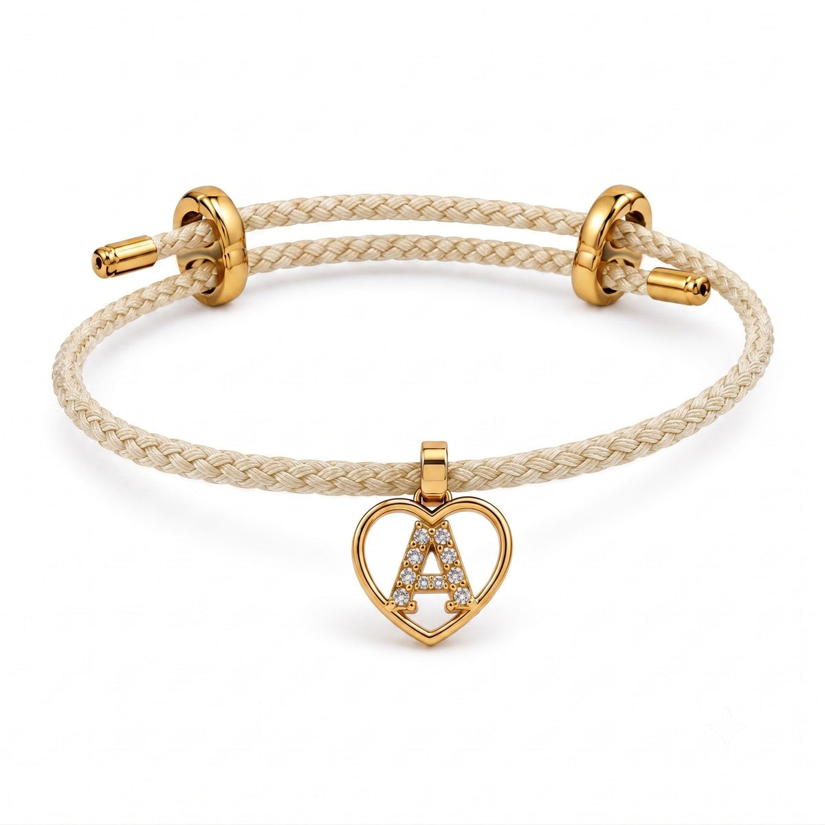 Cream braided adjustable bracelet on a clean white background, featuring a gold heart-shaped pendant with a sparkling letter A initial charm.