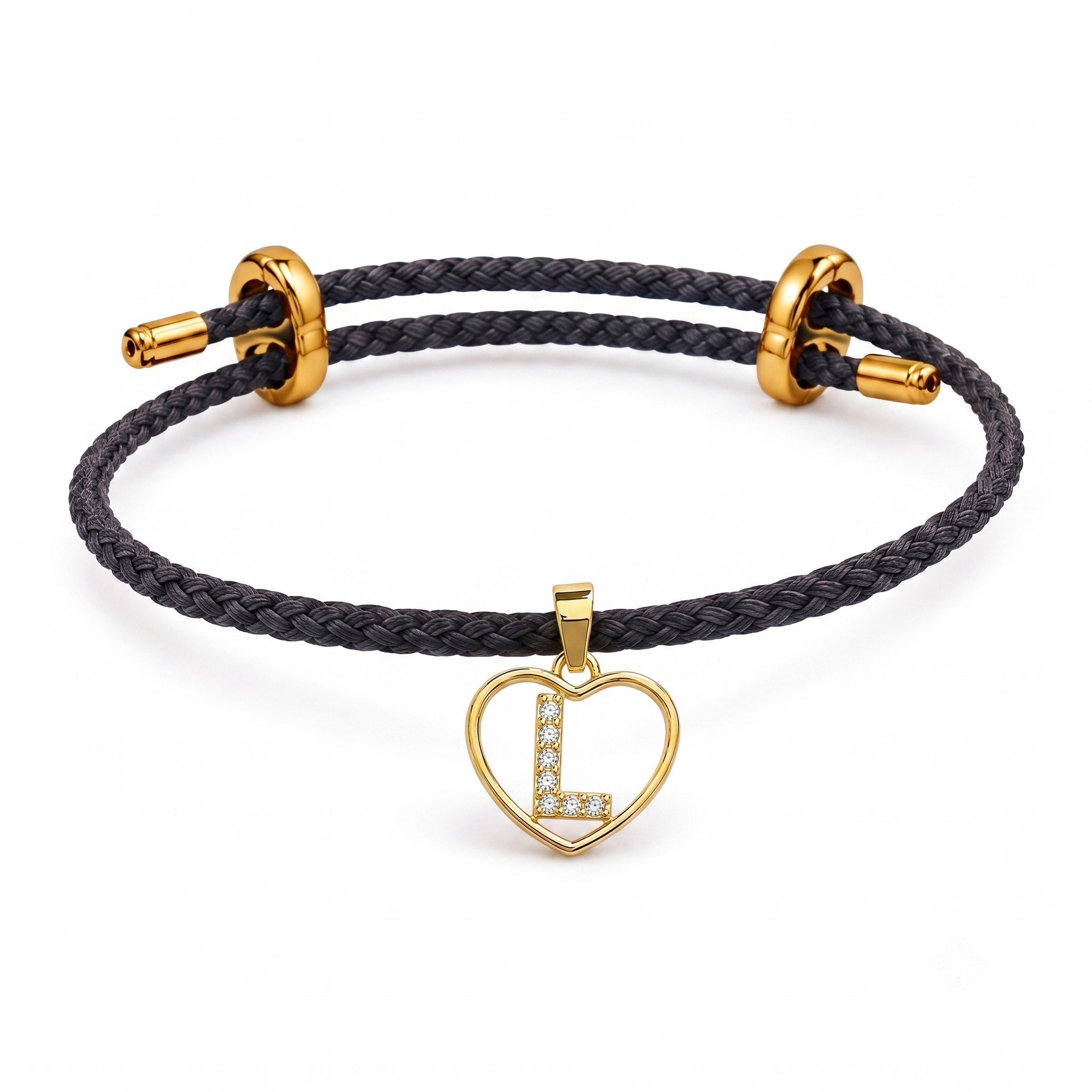This is a dark braided cord bracelet with an adjustable gold clasp and a sparkling heart-shaped initial charm featuring the letter “L.