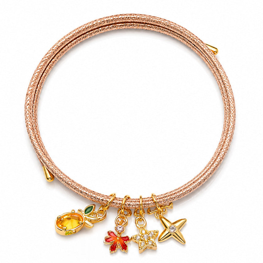 Rose gold braided cord charm bracelet featuring a gold-tone pineapple charm with green leaf detailing, paired with red flower, sparkling star, and crossed star charms, displayed on a clean white background.