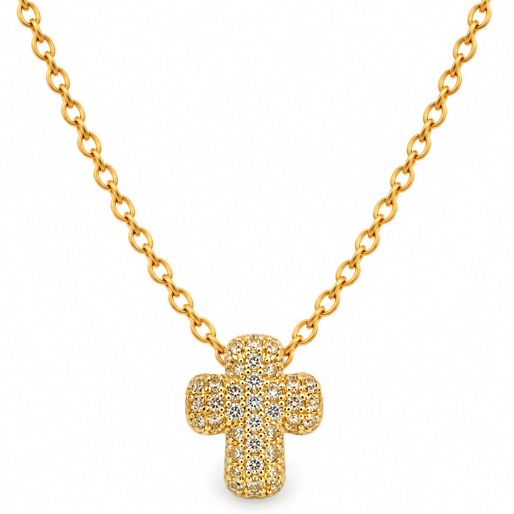 A studio shot of a thin gold link necklace centered with a small, puffy cross charm entirely encrusted with sparkling rhinestones.