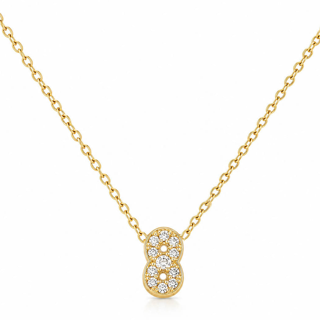 A studio shot of a thin gold link necklace centered with a small number "8" charm entirely encrusted with sparkling rhinestones.