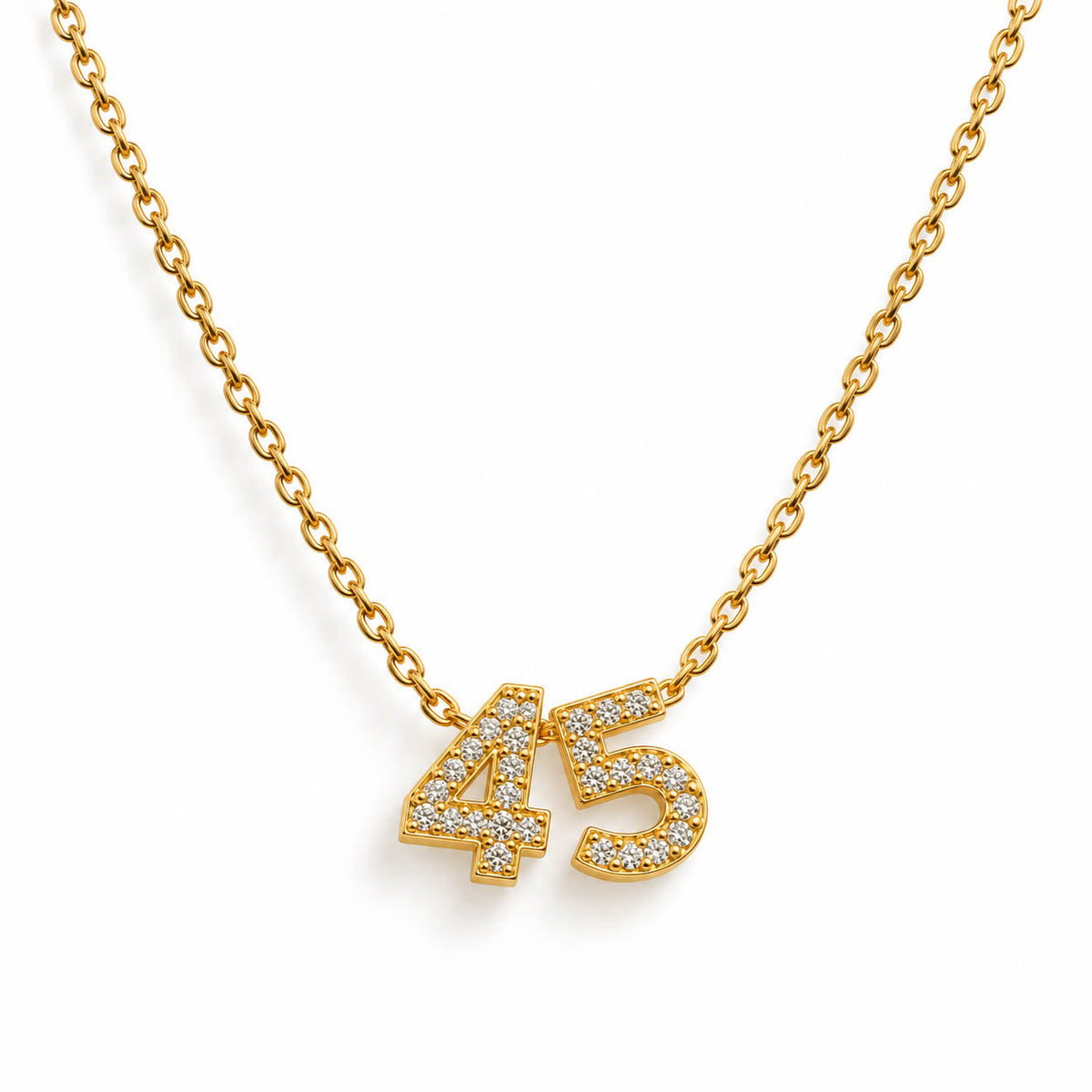 A studio shot of a thin gold link necklace centered with two rhinestone-encrusted charms spelling the number "45".