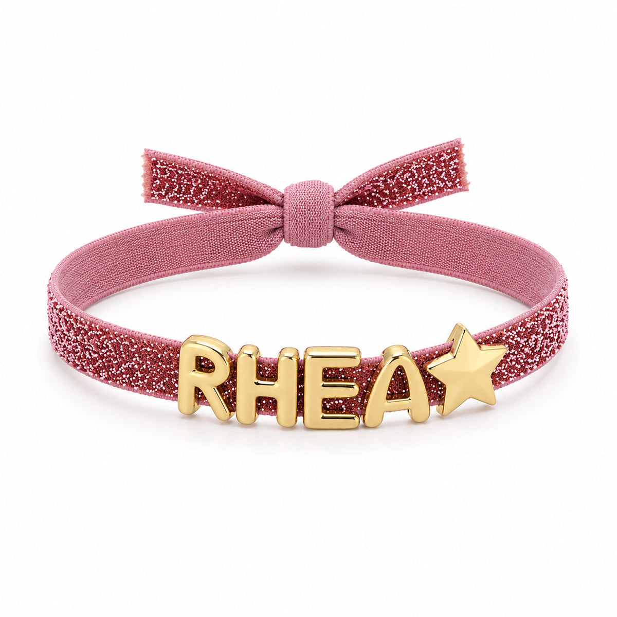 Pink Glitter Bracelet with gold “RHEA” letter charms and a gold star charm, finished with a matching pink fabric bow on a clean white background.