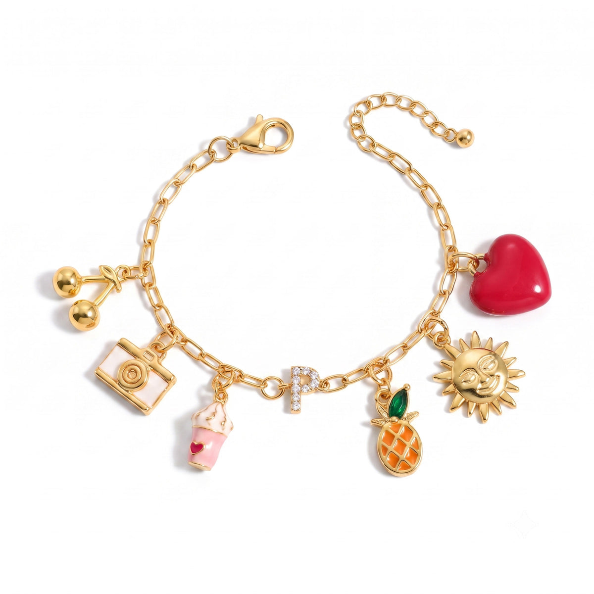 Gold-tone charm bracelet on a white background, featuring a red heart, sun, pineapple, sparkling letter P, drink cup, camera, and round gold charms.