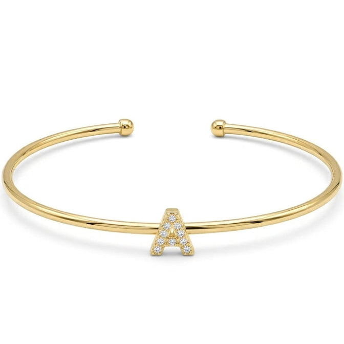 Elegant gold-tone adjustable open cuff bangle featuring a pavé crystal-studded letter A centerpiece. The personalized initial bangle has a sleek polished finish with rounded ball ends and is displayed on a clean white background, making it perfect for everyday wear, stacking, gifting, and personalized jewellery collections.