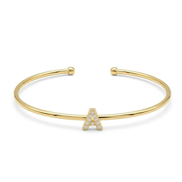 Elegant gold-tone adjustable open cuff bangle featuring a pavé crystal-studded letter A centerpiece. The personalized initial bangle has a sleek polished finish with rounded ball ends and is displayed on a clean white background, making it perfect for everyday wear, stacking, gifting, and personalized jewellery collections.