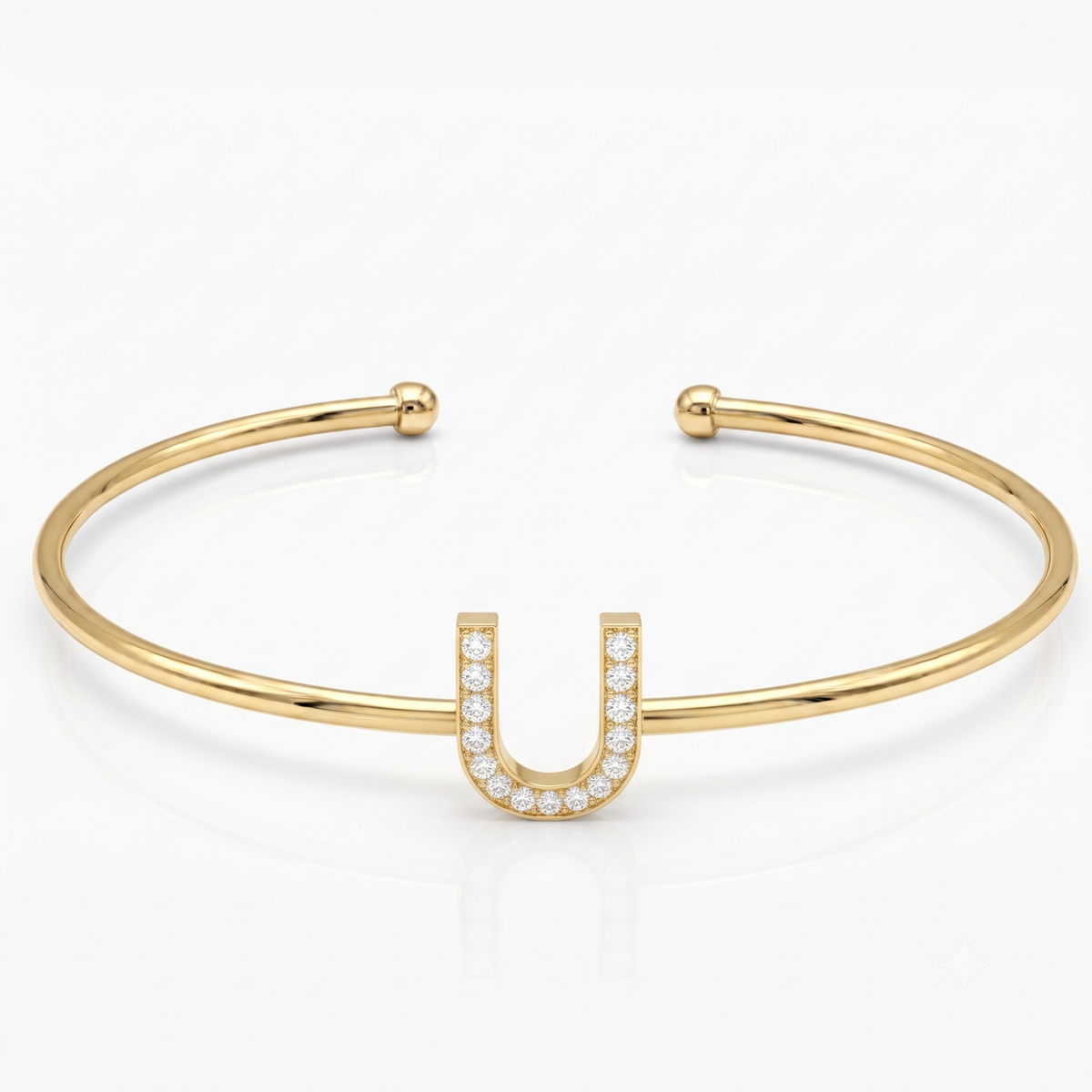 Elegant gold-tone adjustable open cuff bangle featuring a pavé crystal-studded letter U centerpiece. The personalized initial bangle has a sleek polished finish with rounded ball ends and is displayed on a clean white background, making it perfect for everyday wear, stacking, gifting, and personalized jewellery collections.