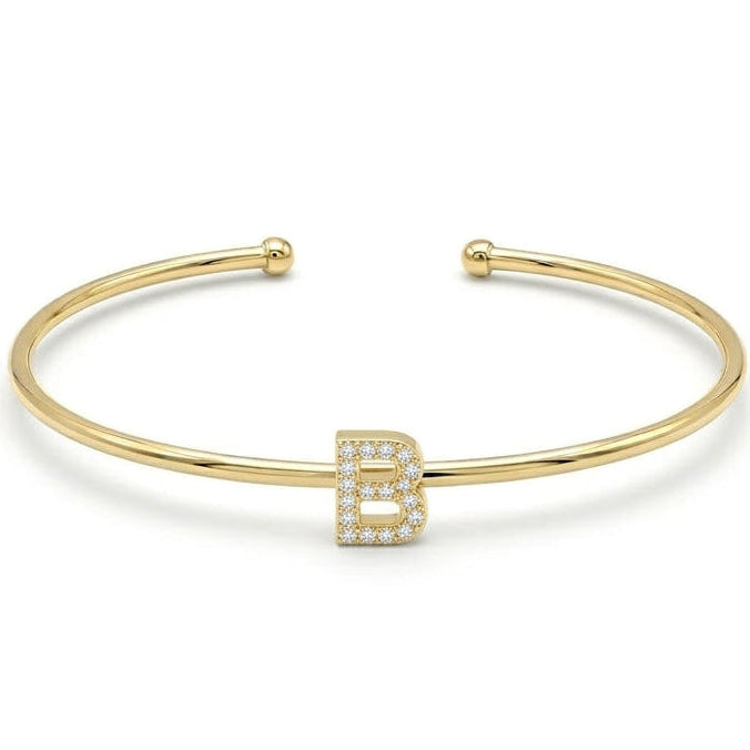 Elegant gold-tone adjustable open cuff bangle featuring a pavé crystal-studded letter B centerpiece. The personalized initial bangle has a sleek polished finish with rounded ball ends and is displayed on a clean white background, making it perfect for everyday wear, stacking, gifting, and personalized jewellery collections.