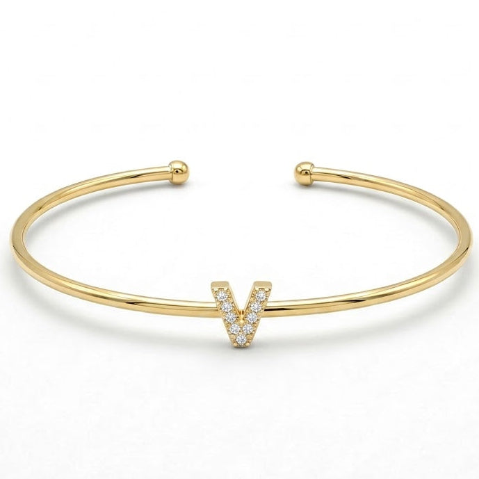 Elegant gold-tone adjustable open cuff bangle featuring a pavé crystal-studded letter V centerpiece. The personalized initial bangle has a sleek polished finish with rounded ball ends and is displayed on a clean white background, making it perfect for everyday wear, stacking, gifting, and personalized jewellery collections.