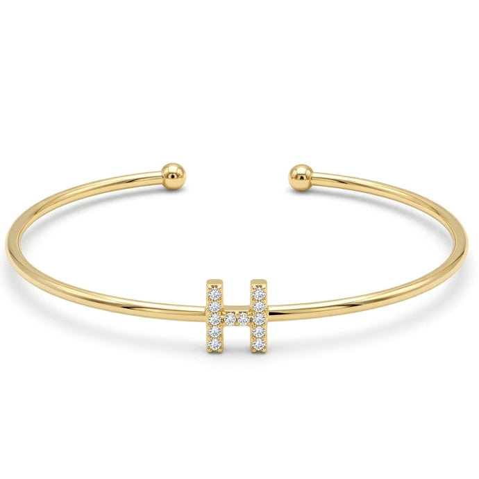 Elegant gold-tone adjustable open cuff bangle featuring a pavé crystal-studded letter H centerpiece. The personalized initial bangle has a sleek polished finish with rounded ball ends and is displayed on a clean white background, making it perfect for everyday wear, stacking, gifting, and personalized jewellery collections.