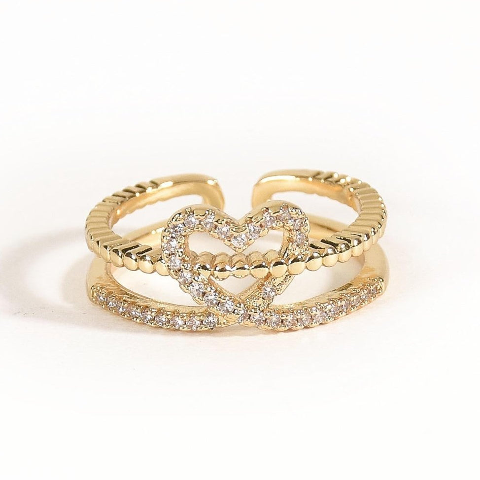 Elegant golden heart ring with twin-band detailing, sparkling pavé accents, and an adjustable anti-tarnish finish, perfect for soft glam styling, everyday elegance, and thoughtful gifting.