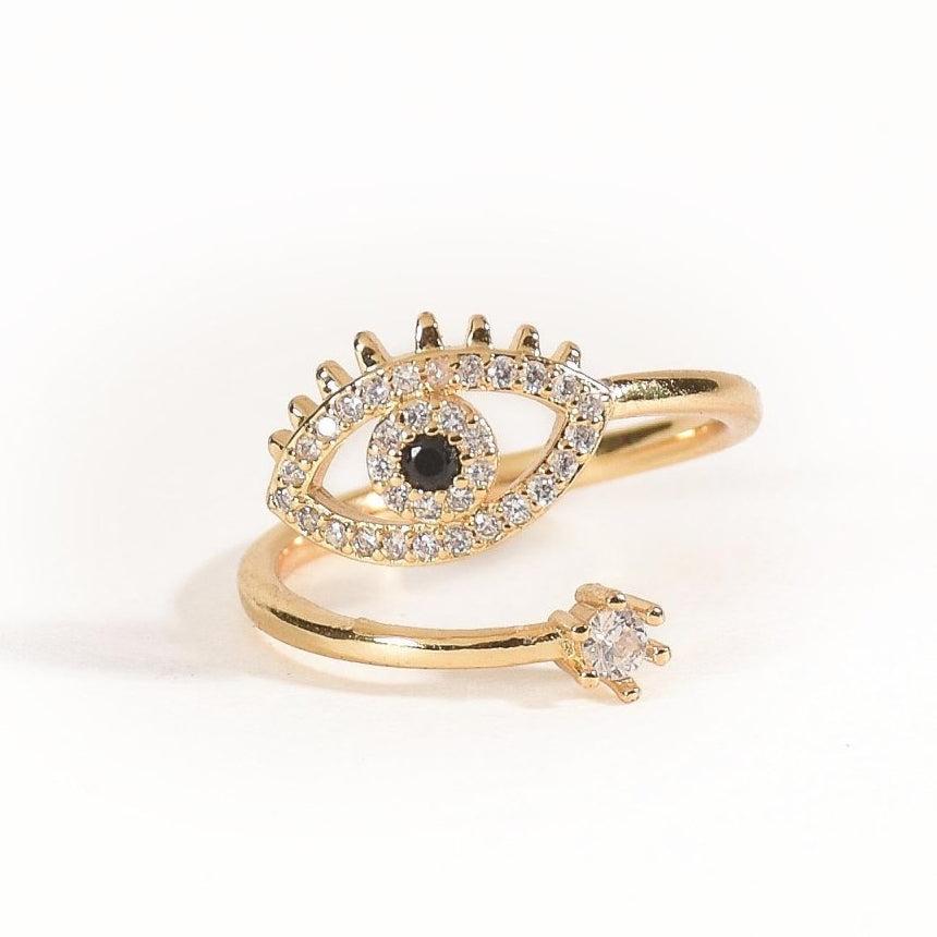 Elegant golden evil-eye ring with sparkling crystal detailing and an adjustable anti-tarnish finish, perfect for everyday glam, layered styling, and adding a chic protective charm to any look.
