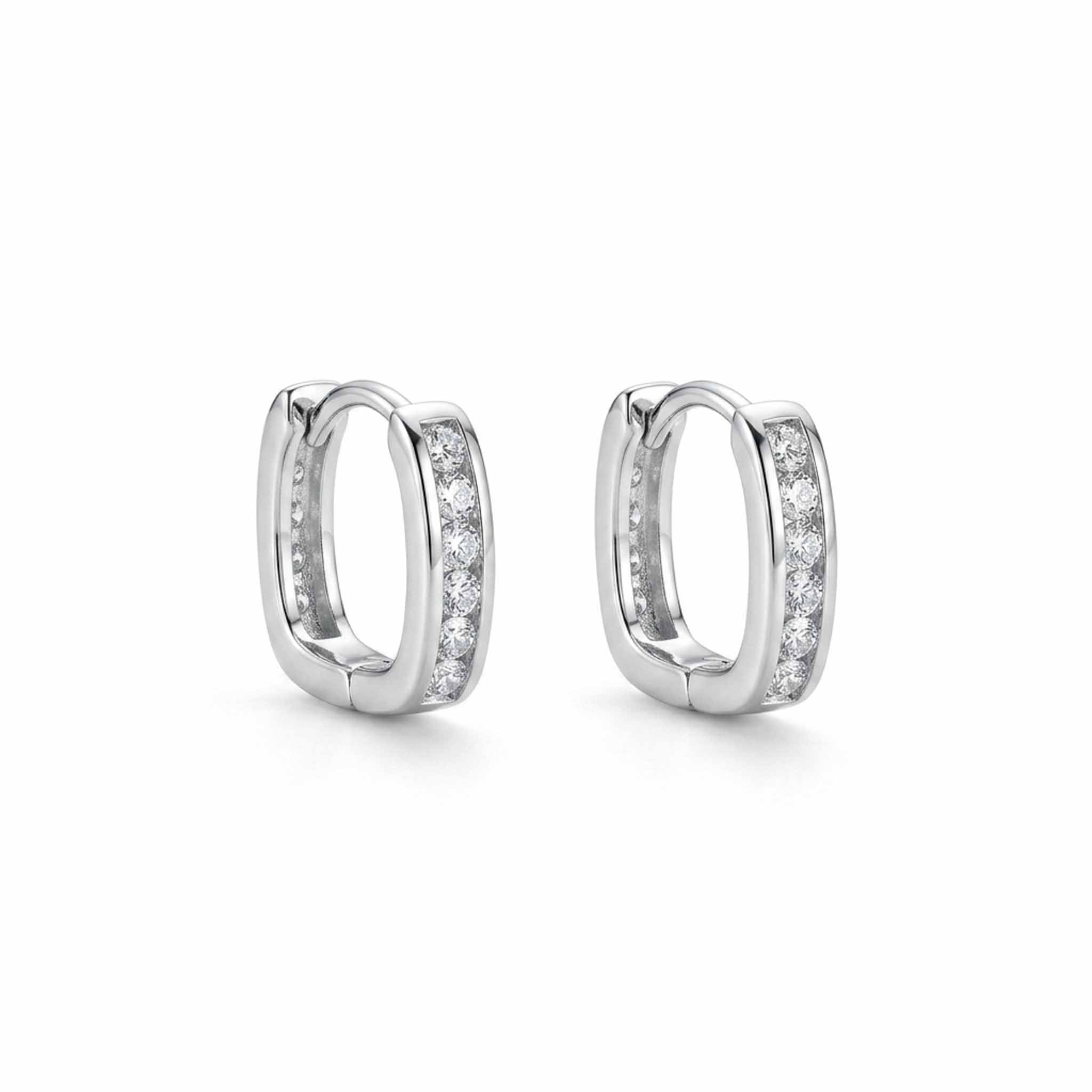 Silver crystal-studded huggie hoop earrings with round-cut stones, displayed on a white background
