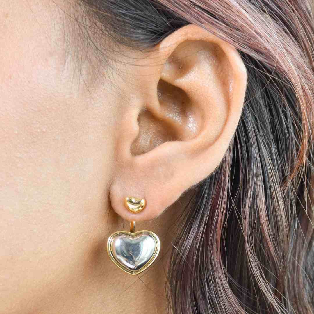 Dreamy heart drop earrings with a two-tone heart design and an anti-tarnish gold finish, perfect for everyday wear and romantic styling.
