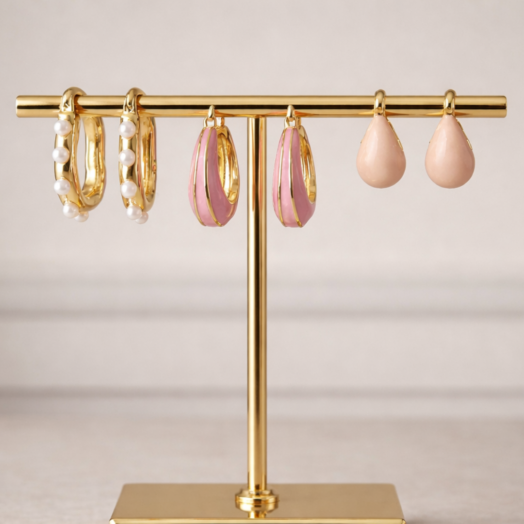 Dreamy pink earring stack with pastel enamel hoops, pearl lined hoops, and soft pink teardrop earrings in gold finish