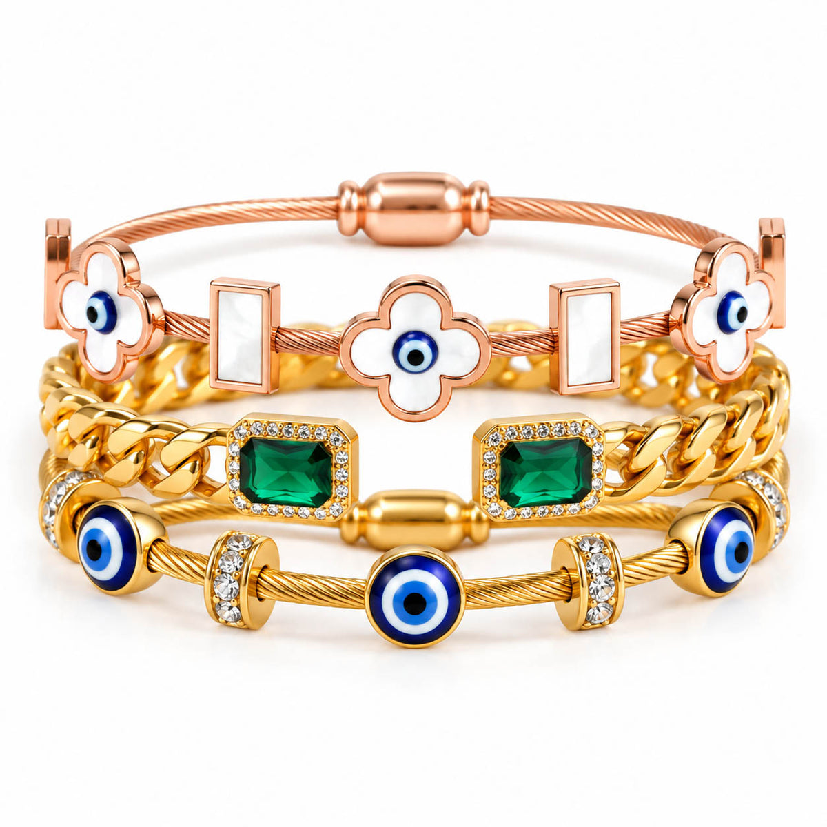 A stack of three anti-tarnish gold-plated bangles featuring a rose gold evil eye clover cuff, a chunky gold chain bangle with emerald-cut green stones, and a gold cable bangle with blue evil eye charms and crystal accents, styled on a clean white background with a premium polished finish.
