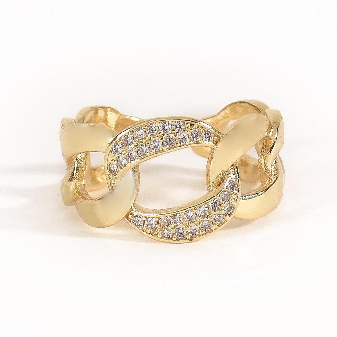 A stack of three adjustable gold-toned rings: a sculptural spike spiral, a chunky chain-link band, and a central signet ring featuring an evil eye symbol.