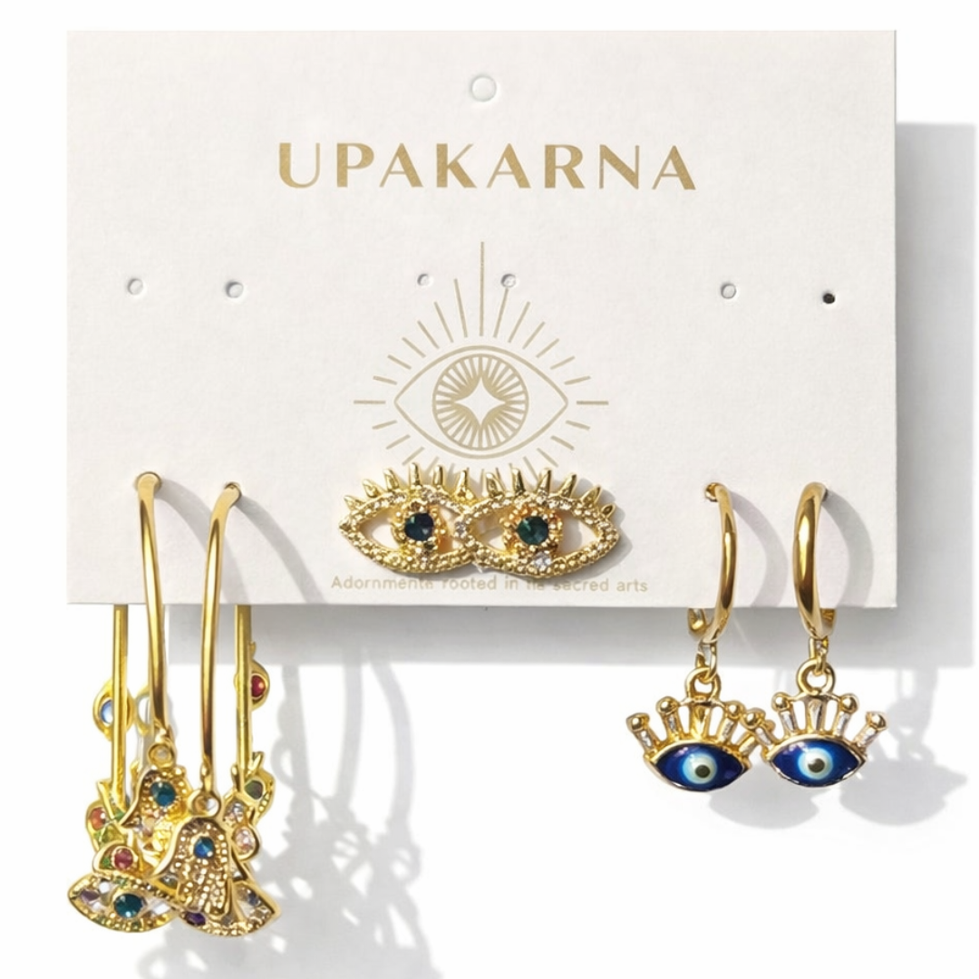 Evil eye earrings set featuring crystal stud, gold hoop with eye charm, and lash design statement earrings