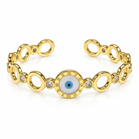 Gold bracelet featuring a prominent blue evil eye centerpiece framed with Roman numeral detailing, alternating polished oval links, and sparkling crystal connectors, displayed on a clean white background.
