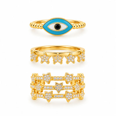 Three gold rings featuring a turquoise evil eye ring, a sparkling star charm ring, and a bold multi-band pavé star ring on a clean white background.