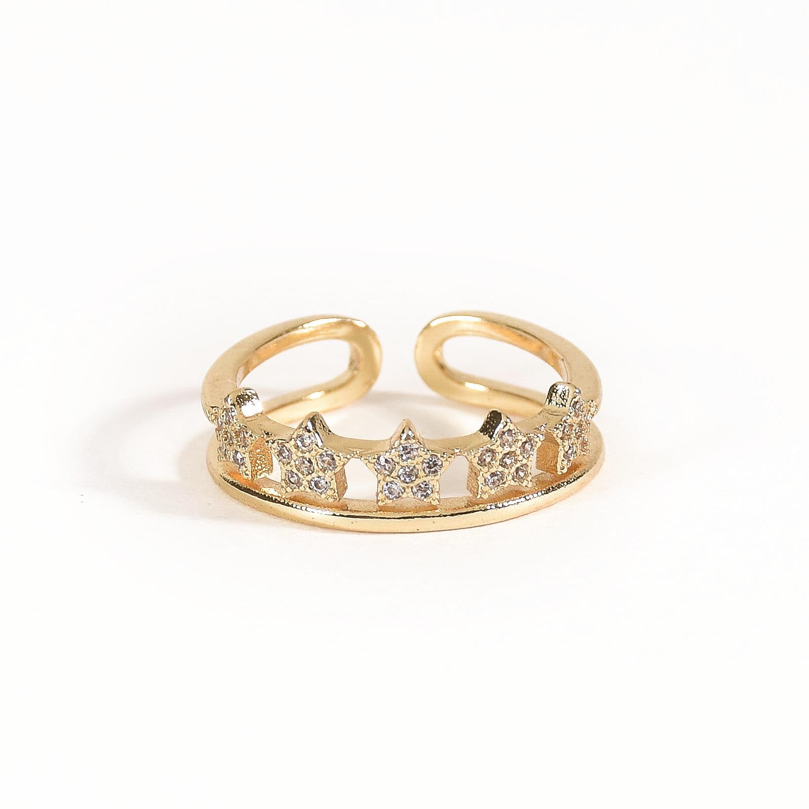 A trio of adjustable gold-toned rings stacked together, featuring a pastel evil eye centerpiece, a sparkling stardust band, and a delicate star-inspired ring.