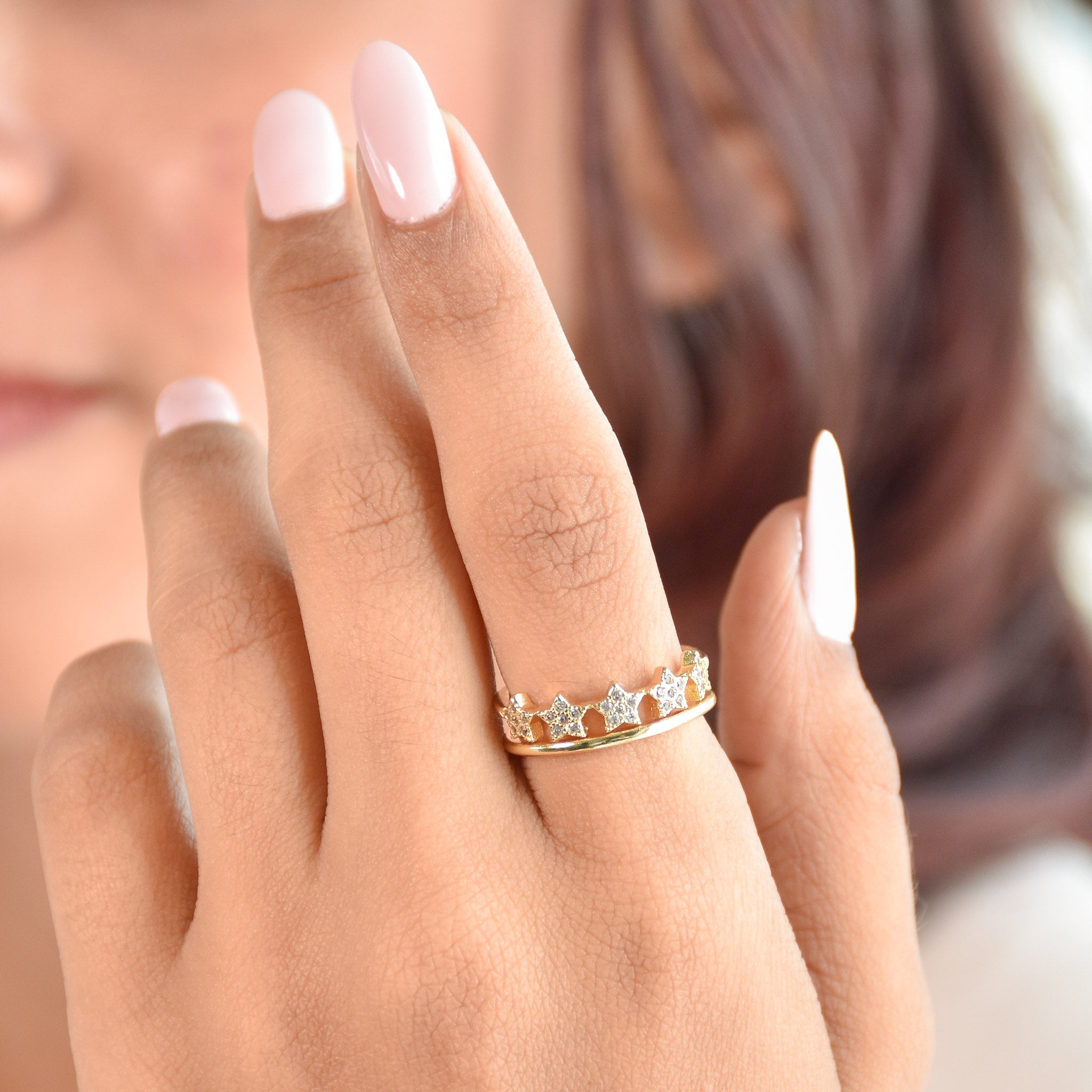 A trio of adjustable gold-toned rings stacked together, featuring a pastel evil eye centerpiece, a sparkling stardust band, and a delicate star-inspired ring.