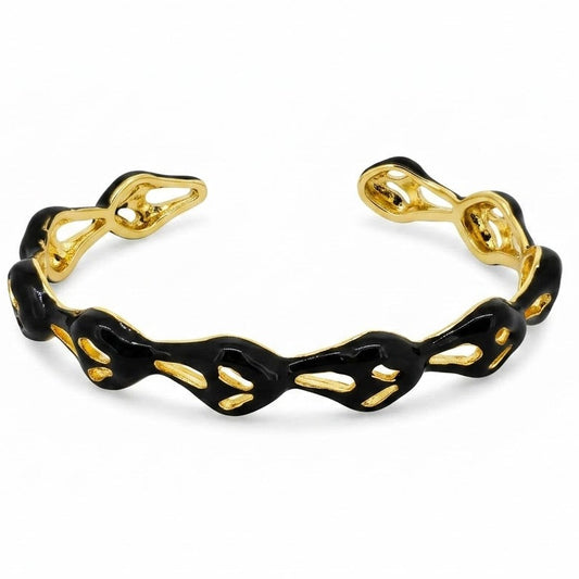 Anti-tarnish yellow gold open cuff bracelet featuring a wavy, fluid openwork band coated in glossy black enamel with teardrop-shaped hollow cutouts.
