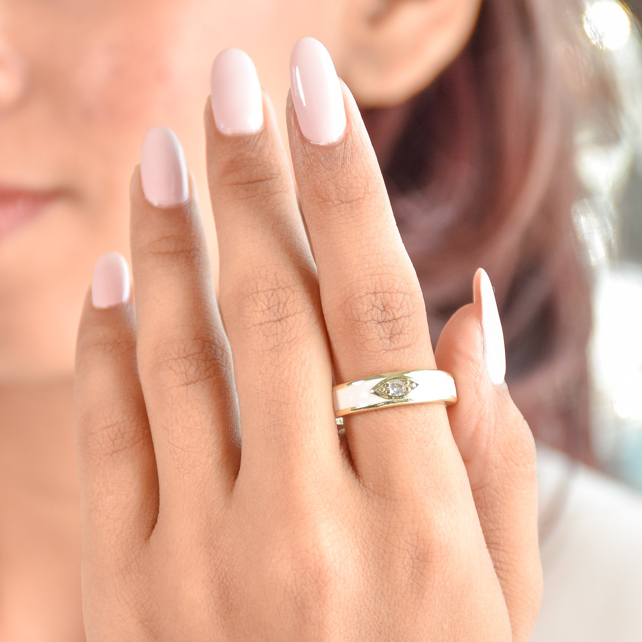 A gold-toned ring stack featuring a blue moonbeam ring, an ivory enamel mystic evil eye, and a crystal-encrusted blink motif.