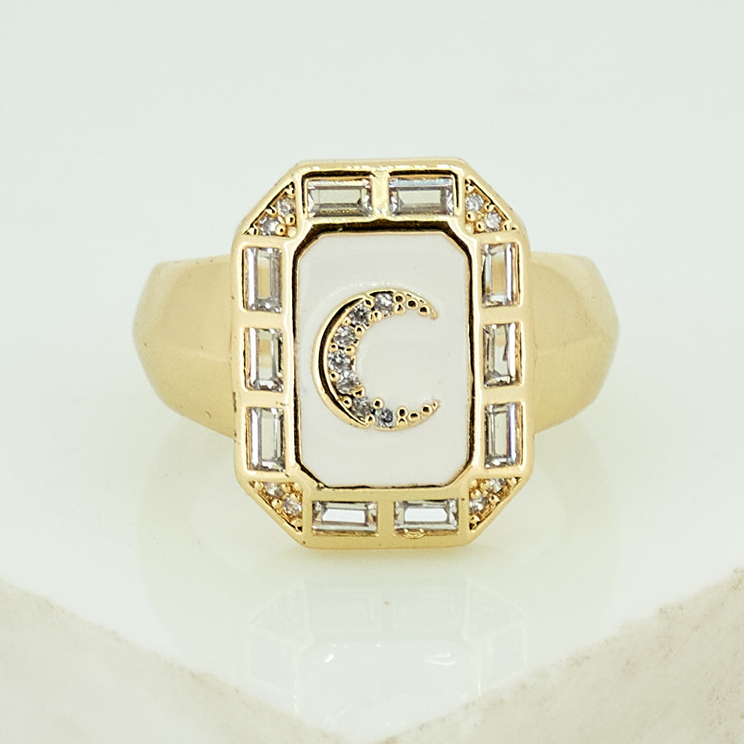 A gold-toned ring stack featuring a blue moonbeam ring, an ivory enamel mystic evil eye, and a crystal-encrusted blink motif.