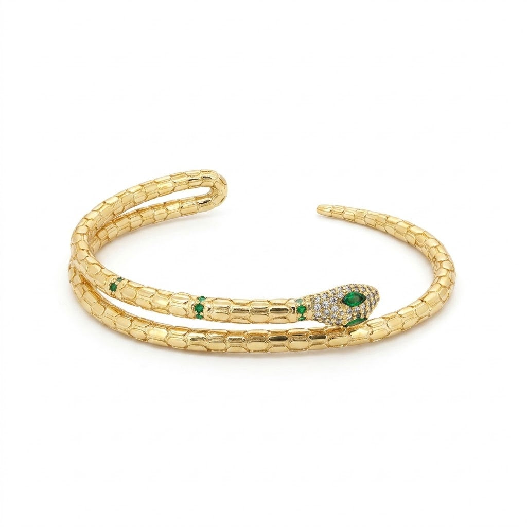 Anti-tarnish gold serpent wrap cuff bracelet featuring a textured python scale body, a pavé cubic zirconia crystal-paved head with marquise green emerald eyes, and green stone accents along the neck.