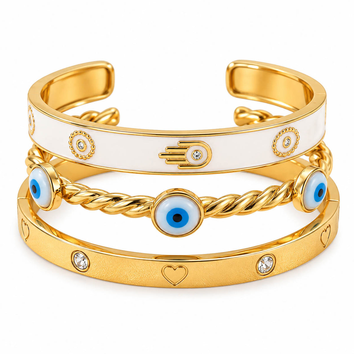 Premium 3-piece gold bracelet stack featuring a white enamel Hamsa cuff bangle, twisted Evil Eye bracelet with blue eye charms, and a crystal heart engraved cuff on a white background.